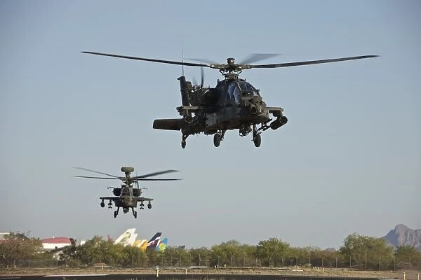 A pair of AH-64D Apache Longbow helicopters taking off