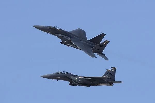 A pair of F-15C Eagle aircraft perform maneuvers at an airshow