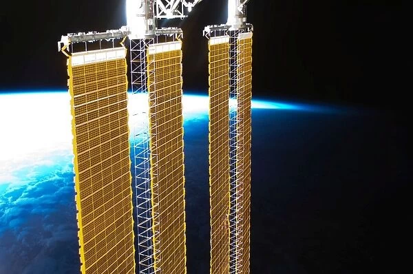 A partial view of International Space Station solar panels and Earths horizon