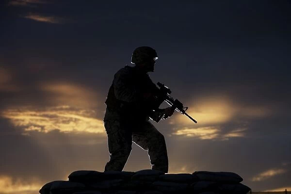 Partially silhouetted U. S. Marine on a bunker in Northern Afghanistan