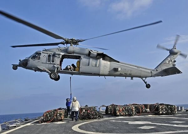 Sailors attach a cargo pennant to a MH-60S Sea Hawk helicopter