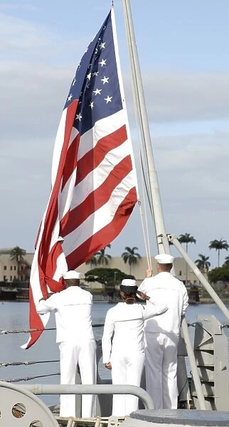 Sailors hoist the American flag for morning colors aboard the Battleship Missouri