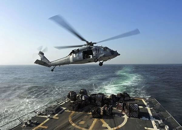 An SH-60R Sea Hawk delivers pallets during a replenishment at sea