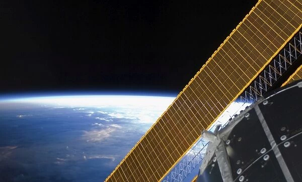 Solar array panels on the International Space Station backdropped against Earths horizon