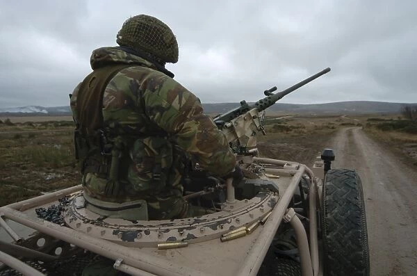 A soldier mans a. 50 caliber machine gun atop a Pink Panther Land Rover