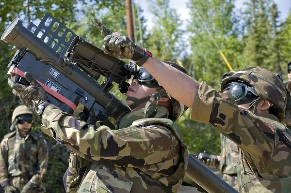 A soldier operates a missile launcher while his teammate locates the target