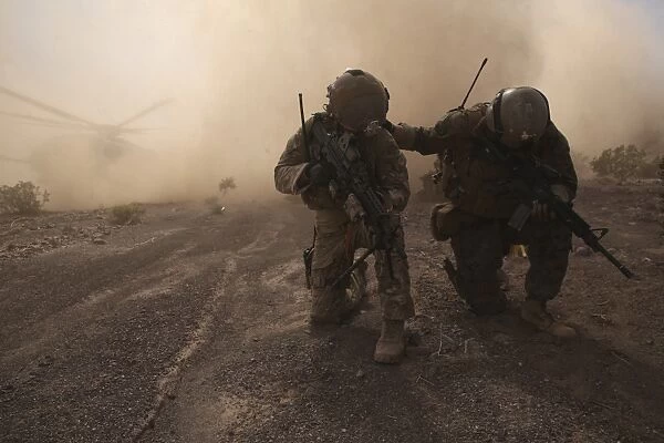 Soldiers brace for the impact of a cloud of sand and rocks from a landing CH-53 Super