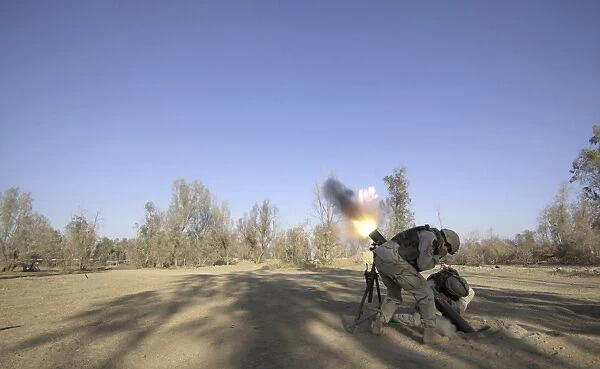 U. S. Army soldiers firing a 120-millimeter mortar round from Forward Operating Base