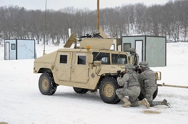 U. S. soldiers take cover behind a humvee during Combat Support Training Exercises