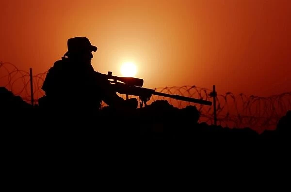 A U. S. Special Forces soldier armed with a Mk-12 Sniper Rifle at sunset