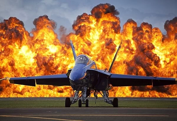 A wall of fire erupts behind a U. S. Navy F  /  A-18 Hornet aircraft