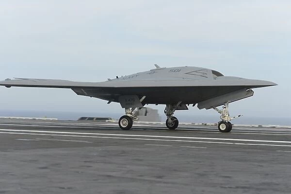 An X-47B unmanned combat air system conducts a touch and go landing