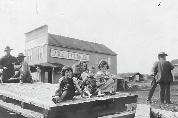 Children outside Eagle Trading Company, between c1900 and 1916. Creator: Unknown