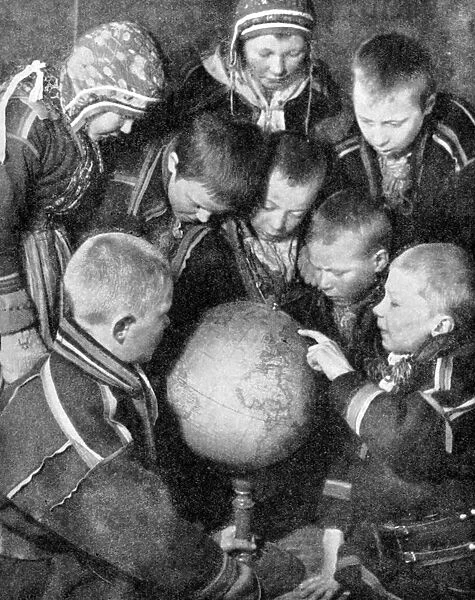 Lapp children looking at a globe, 1936