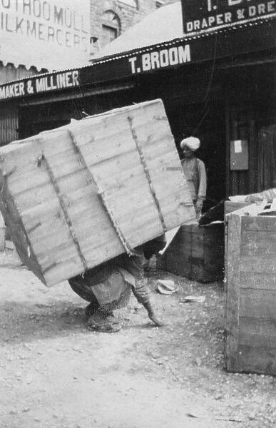 A porter lifting a large load, Chakrata, India, 1917