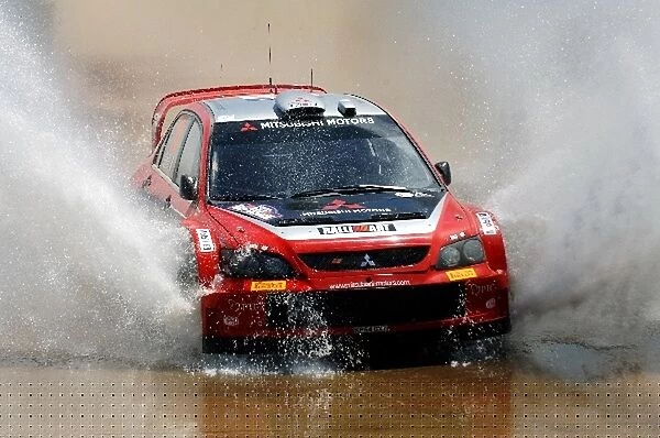 FIA World Rally Championship: Gigi Galli with co-driver Guido D Amore Mitsubishi Lancer EVO through the water splash on Stage 12