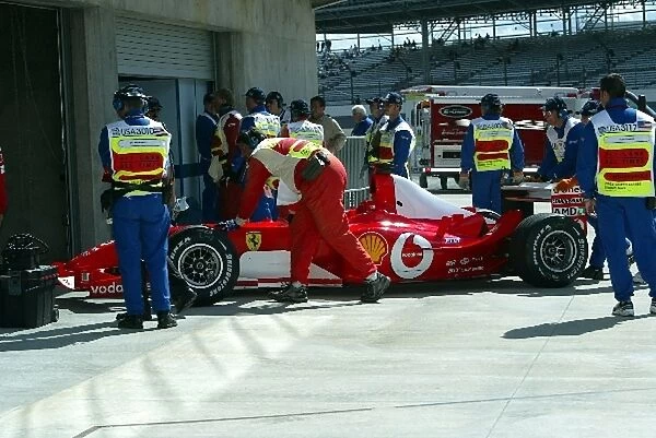 Formula One World Championship: A Ferrari is pushed into parc ferme during qualifying