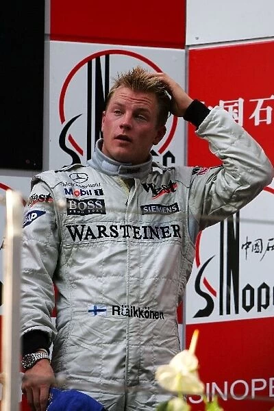 Formula One World Championship: Third place finisher Kimi Raikkonen celebrates on the podium