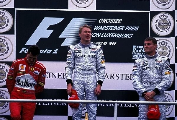 Formula One World Championship: The podium finishers Michael Schumacher Ferrari 2nd, Mika Hakkinen 1st, David Coulthard McLaren 3rd