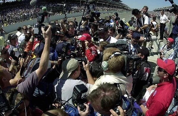 Helio Castroneves (BRA) Team Penske is mobbed by the media following his controversial victory of the 86th