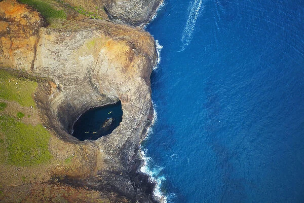 Aerial View Of The Rugged Coastline And Tide Pool In A Hole Along An Hawaiian Island; Na Pali Coast Of Kauai, Hawaii, United States Of America
