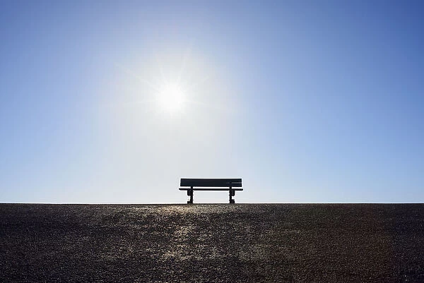 Bench on Dike with Sun by North Sea, Westkapelle, Zeeland, Netherlands