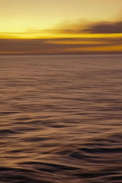 Hawaii, Maui, Ocean waves in motion and a vibrant tropical sunset