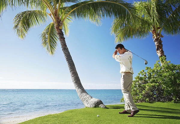 Hawaii, Oahu, Male Playing Golf, Ready To Swing His Golf Club At A Beach Front Golf Course