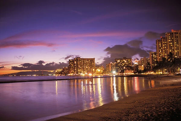 Hawaii, Oahu, Waikiki Beach, Reflection Of City Lights On The Ocean At Twilight