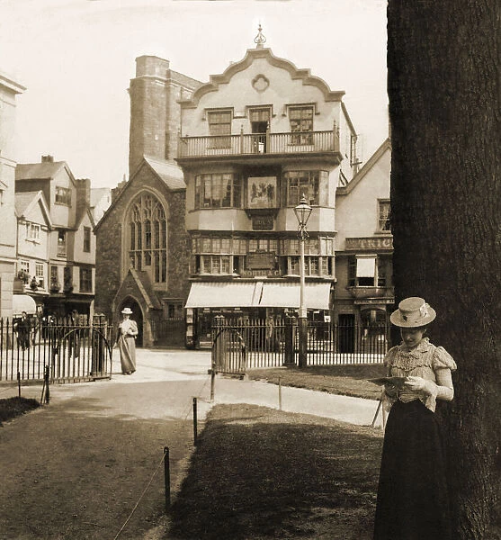 Historic image in sepia tone of a lady reading a book under a tree outside Martin Street Baptist Church circa 1900 in Raleigh; Raleigh, North Carolina, United States of America