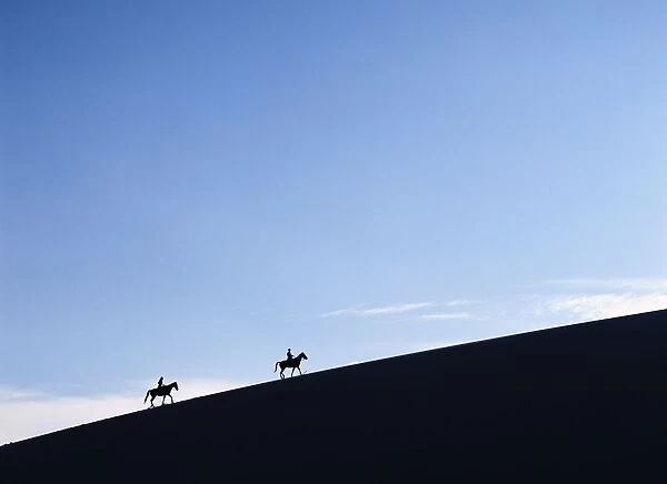 Horse Riders At Dusk On A Sand Dune In The Valle De La Muerte In Cordillera De La Sal Mountains