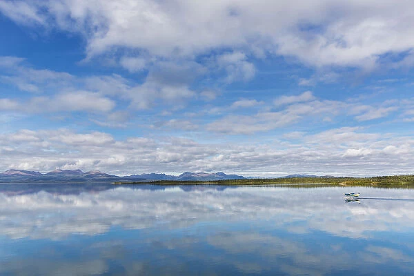 Light Clouds Reflect On The Calm Water Of Tikchik Lake At The Tikchik Narrows Lodge, Wood Tikchik State Park, Southwestern Alaska; Alaska, United States Of America