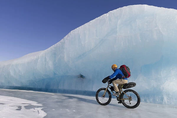 Man Fat Tire Mountain Biking On Ice At The Knik Glacier, Chugach Mountains, Southcentral Alaska, Winter