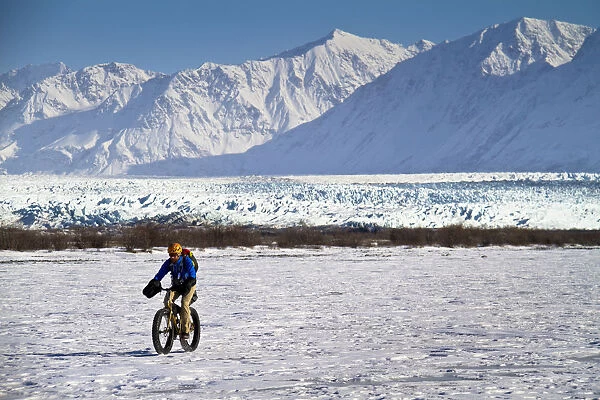 Man Fat Tire Mountain Biking On The Knik Glacier, Chugach Mountains, Southcentral Alaska, Winter
