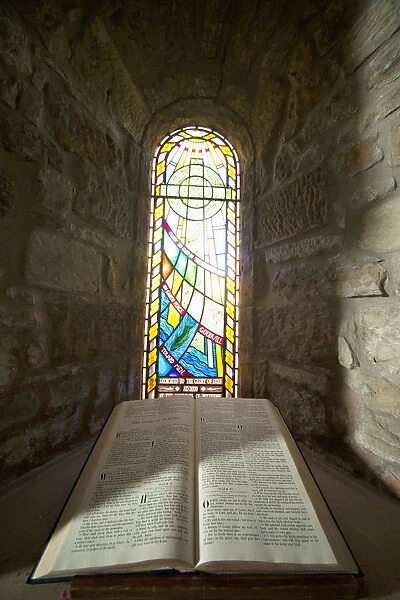 An Open Bible And A Stained Glass Window In St. Marys Church; Holystone, Northumberland, England