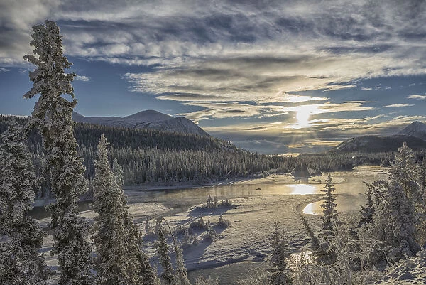 The Sun Breaks Through The Clouds Above The Takhini River On A Late Winter Afternoon, Near Whitehorse; Yukon, Canada