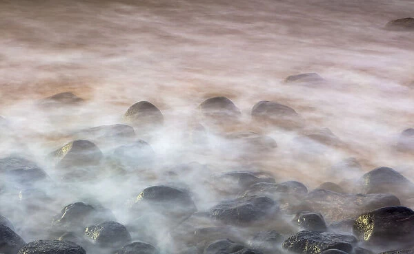 Water washing over rocks on beach