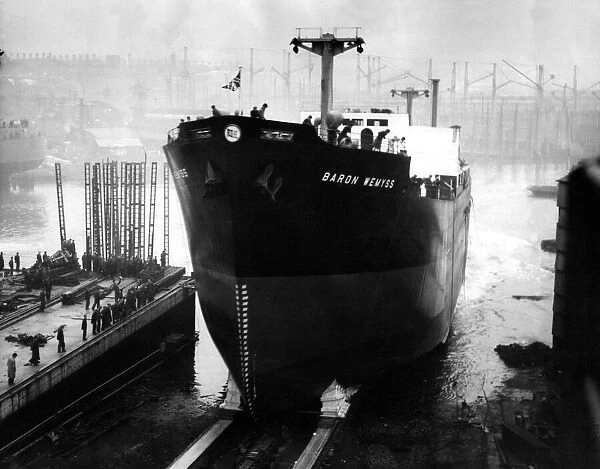 The 11, 500-ton cargo ship Baron Wemyss slides down the slipway at the shipyard of Austin