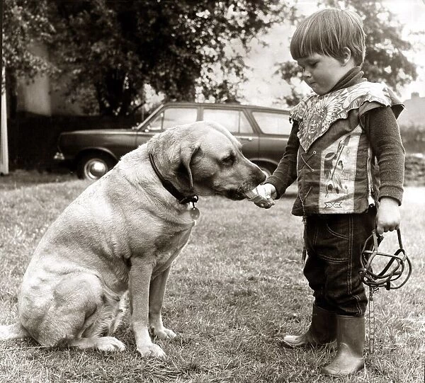 2 year old Edward Turner feeding an ice cream to his pet labrador Glen after removing his