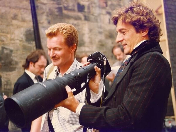 Actor Nigel Havers inspecting photographer Nigel Roddiss camera and lens