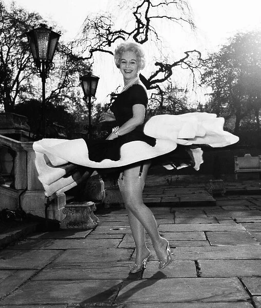Actress Eva Gabor gives a twirl in her dress April 1957