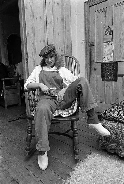 Actress Helen Mirren seated in her country Windsor chair wearing her favorite cap