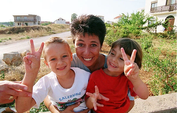 Aid worker Sally Becker pictured in Bosnia with children during war in Yugoslavia