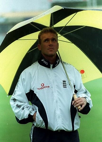 Alecd Stewart England Cricket Captain June 1998 stands under an umbrella at