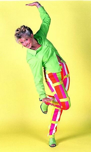 Alison Douglas TV Presenter with hair tied up wearing bright coloured trousers