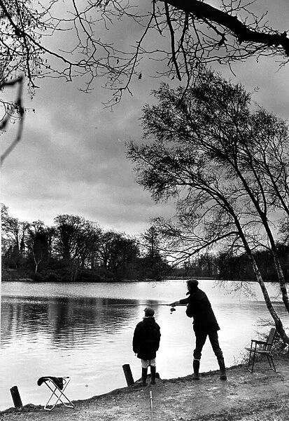 Angling. A young boy fishing with his father at Coombe Abbey pool
