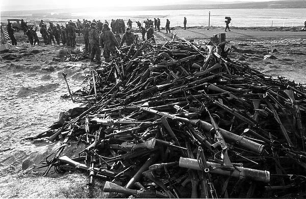 ARGENTINE SOLDIERS SURRENDER RIFLES EN ROUTE FROM STANLEY TO THE AIRPORT AT THE END OF
