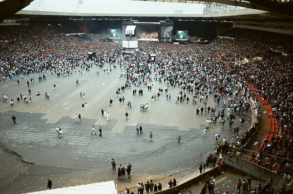 Audience gathered around the stage at Wembley where Michael Jackson can be seen