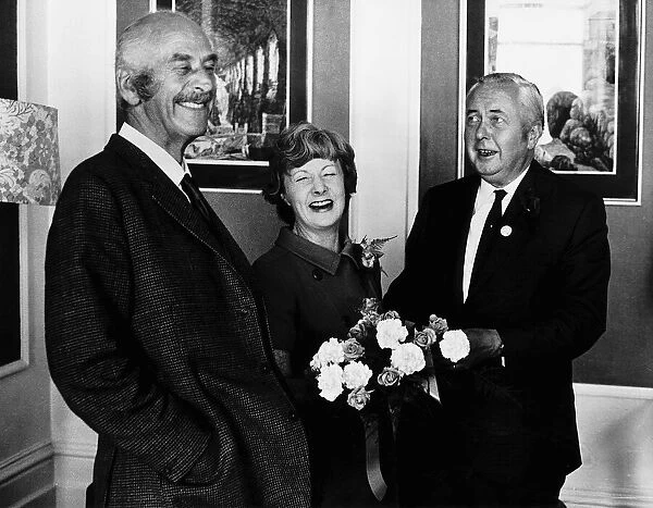 Barbara Castle receives cake and flowers on her birthday from Harold Wilson (R) 1971