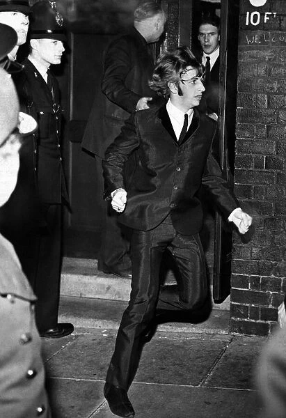 Beatles drummer Ringo Starr bolts from a side exit to a waiting car after the band